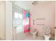 Bright bathroom with fun pink accents, accessible grab bars, and tiled shower with glass door at 1403 5Th Pl, Las Vegas, NV 89104