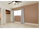 Bedroom with light brown walls, ceiling fan, tiled floor, and open closet with built-in shelves at 1403 5Th Pl, Las Vegas, NV 89104