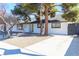 White painted brick home with a dark roof, trees, desert landscaping, and a charming bright green door at 1403 5Th Pl, Las Vegas, NV 89104