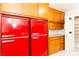 Retro kitchen with bright red Galanz refrigerators, wood cabinetry and a large pantry at 1403 5Th Pl, Las Vegas, NV 89104