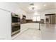 Modern kitchen featuring sleek white cabinetry, stainless steel appliances, and stone countertops at 1403 5Th Pl, Las Vegas, NV 89104