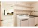 Bright laundry room features a washer, dryer, sink and lots of open shelving for storage at 1403 5Th Pl, Las Vegas, NV 89104