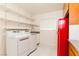 A well-organized laundry area with floating shelves, a vintage refrigerator, and modern appliances at 1403 5Th Pl, Las Vegas, NV 89104