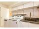Bright laundry room featuring a washing machine, dryer, sink, and ample shelving at 1403 5Th Pl, Las Vegas, NV 89104