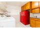 Functional laundry area featuring modern appliances, ample cabinet space, and a vintage red refrigerator at 1403 5Th Pl, Las Vegas, NV 89104