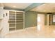 Bright living room featuring custom built-in shelving, ceiling fan, and light, glossy tile flooring at 1403 5Th Pl, Las Vegas, NV 89104