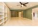 Bright living room featuring custom built-in shelving, ceiling fan, and light, glossy tile flooring at 1403 5Th Pl, Las Vegas, NV 89104