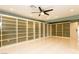 Bright living room featuring custom built-in shelving, ceiling fan, and light, glossy tile flooring at 1403 5Th Pl, Las Vegas, NV 89104