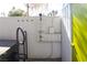 Outdoor shower with white wall details and a lime green door near the hot tub in backyard at 1403 5Th Pl, Las Vegas, NV 89104