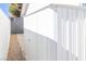 A white, corrugated metal storage shed sits next to the property line at 1403 5Th Pl, Las Vegas, NV 89104