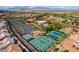 Aerial view of tennis courts and lush green landscape in a community with homes at 2540 Youngdale Dr, Las Vegas, NV 89134