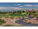 A pristine golf course featuring lush green fairways, sand traps, and picturesque landscaping, with a winding cart path at 2540 Youngdale Dr, Las Vegas, NV 89134