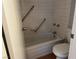 An older bathroom with a tub, tile, and grab bars for accessibility at 2679 Jacyra Ave, Las Vegas, NV 89121