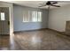 Neutral living room with tile flooring, ceiling fan, brick fireplace, and natural light from the window at 2679 Jacyra Ave, Las Vegas, NV 89121