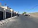 A long street view shows parked cars, garages, and lush palm trees on a sunny day at 2679 Jacyra Ave, Las Vegas, NV 89121