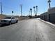 A long street view shows parked cars, tall palm trees and a view of the mountains in the distance at 2679 Jacyra Ave, Las Vegas, NV 89121