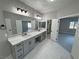 Bathroom featuring double sinks, granite countertops, gray cabinets, and modern lighting at 2700 W Carnation Way, Pahrump, NV 89048