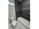 Bathroom featuring a toilet and bathtub with dark tiled walls at 2700 W Carnation Way, Pahrump, NV 89048