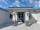 Modern front entrance featuring a black door with frosted glass panels and stone accents at 2700 W Carnation Way, Pahrump, NV 89048