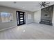 Sunlit living room featuring a modern fireplace, contemporary front door, and gray wood-look flooring at 2700 W Carnation Way, Pahrump, NV 89048