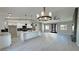 Open living space featuring a modern kitchen with an island, contemporary lighting, and gray wood-look floors at 2700 W Carnation Way, Pahrump, NV 89048