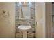 Small bathroom with pedestal sink and stone tile accents at 2721 Tahiti Isle Ave, North Las Vegas, NV 89031