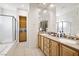 Bright bathroom featuring double sinks, wood cabinets, and glass shower at 2794 Evening Rock St, Las Vegas, NV 89135