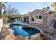 Beautiful backyard pool with rock features and a stone accented home in a tranquil setting at 2794 Evening Rock St, Las Vegas, NV 89135