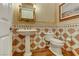 Elegant powder bathroom with tiled walls, pedestal sink, decorative mirror and adjacent toilet at 308 Bayswater Ct, Las Vegas, NV 89145