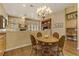 Cozy dining area adjacent to the kitchen, with a wooden table, chandelier, and comfortable seating at 308 Bayswater Ct, Las Vegas, NV 89145