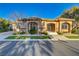 Elegant single-story home with arched windows, stone accents, and lush landscaping at 308 Bayswater Ct, Las Vegas, NV 89145