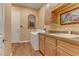 Well-lit laundry room with modern washer/dryer, built-in sink, cabinets, and a charming arched window at 308 Bayswater Ct, Las Vegas, NV 89145