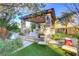 Outdoor kitchen and seating area with ceiling fan and manicured landscaping at 308 Bayswater Ct, Las Vegas, NV 89145