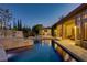 Inviting backyard pool at twilight features travertine deck, outdoor living area, and lush landscaping at 308 Bayswater Ct, Las Vegas, NV 89145