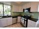 Bright kitchen with stainless steel appliances and green tile backsplash at 3126 Asoleado Cir, Las Vegas, NV 89121