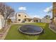 Home exterior with manicured lawn, fenced yard, trampoline, covered patio, and mature trees at 319 Horse Pointe Ave, North Las Vegas, NV 89084