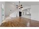 Bright living room with wood floors, high ceilings, ceiling fan, and view of the open-concept kitchen and staircase at 319 Horse Pointe Ave, North Las Vegas, NV 89084