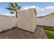 Beige storage shed with white trim and brick paver patio at 319 Horse Pointe Ave, North Las Vegas, NV 89084