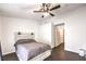 Charming bedroom with ceiling fan and dark herringbone floors at 320 Mindoro Ave, North Las Vegas, NV 89031