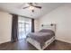 Spacious bedroom with dark herringbone floors, ceiling fan and large windows at 320 Mindoro Ave, North Las Vegas, NV 89031