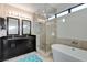 Bright bathroom featuring a dual sink vanity, sleek shower, and modern soaking tub at 4565 Dean Martin Dr # 102, Las Vegas, NV 89103