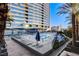 Exterior shot of an outdoor pool area surrounded by lounge chairs and palm trees at 4565 Dean Martin Dr # 102, Las Vegas, NV 89103