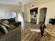 Spacious living room with hardwood floors, sectional sofa, and large TV at 4604 Possum Berry Ln, North Las Vegas, NV 89081