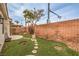 Inviting backyard featuring a landscaped design with faux grass and a decorative brick perimeter wall at 4731 Norwegian St, Las Vegas, NV 89147