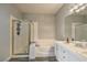 Bright bathroom featuring a separate tub and glass enclosed shower with white cabinets and grey wood flooring at 4731 Norwegian St, Las Vegas, NV 89147