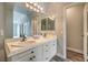 Bright bathroom featuring double sinks with white cabinets, modern light fixture, and a large mirror at 4731 Norwegian St, Las Vegas, NV 89147