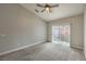 Light-filled bedroom with carpet, ceiling fan, and access to the backyard through sliding glass doors at 4731 Norwegian St, Las Vegas, NV 89147