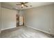 Spacious bedroom with neutral carpet, ceiling fan, and doorway leading to the bathroom at 4731 Norwegian St, Las Vegas, NV 89147