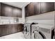 Bright laundry room with dark cabinets and matching washer and dryer at 5 Highland Cove Ln, Henderson, NV 89011