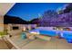 Night view of a luxurious pool and patio area with fire pit at 5 Highland Cove Ln, Henderson, NV 89011